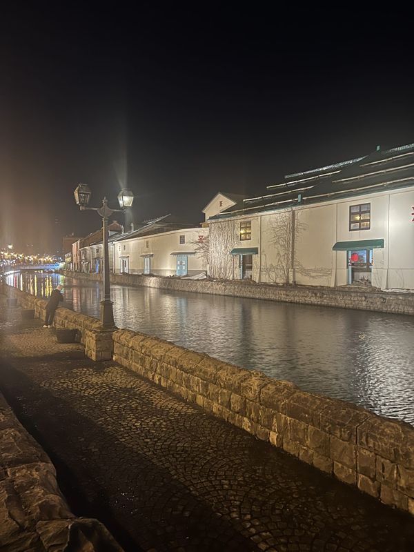 The Otaru Canal at night, stone warehouses lit along the water