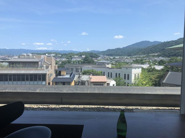 The view from the club lounge counter at The Westin Miyako Kyoto over tiled rooftops towards the wooded Higashiyama hills, wi