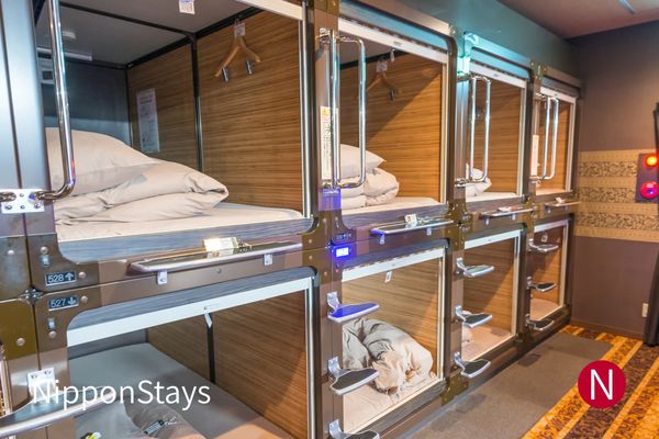 Wooden capsule hotel bunks with open sleeping pods