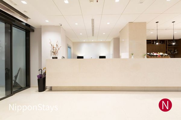 An empty hotel reception desk in a bright lobby