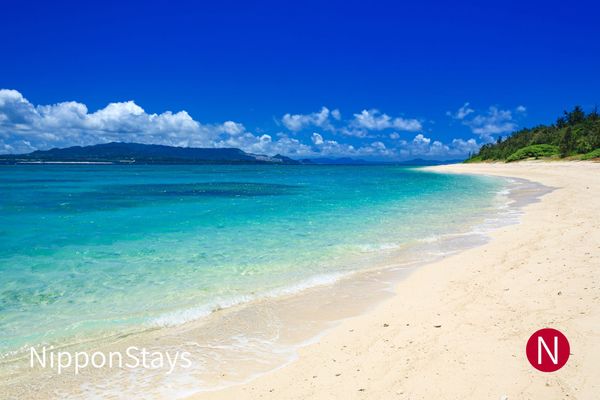 A white sand beach and shallow blue water in Okinawa