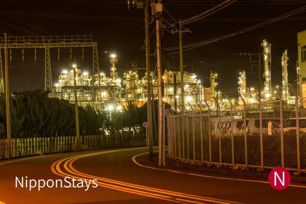 An industrial complex lit up across the water at night