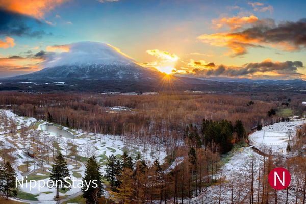 Mount Yotei rising above snow-covered fields near Niseko at sunset