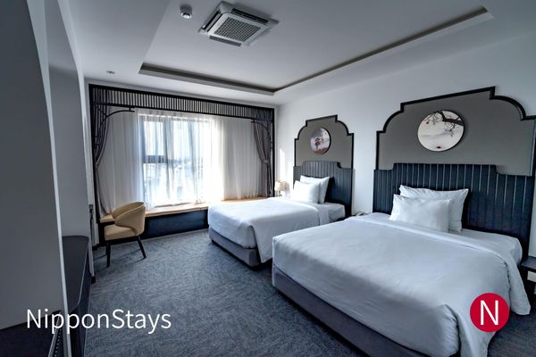 A modern hotel room with two beds side by side
