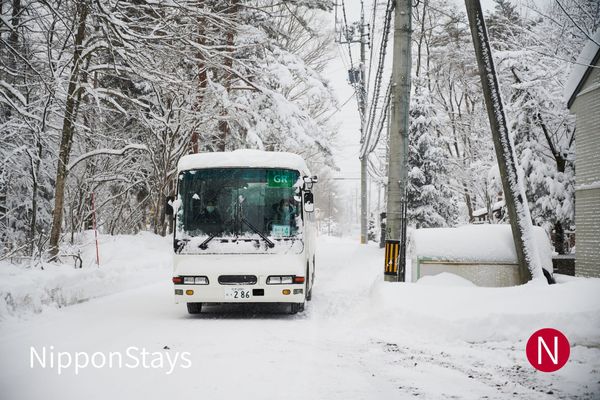 A white coach running along a snow-covered road between winter trees
