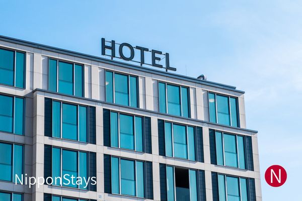 A mid-rise city hotel with a plain HOTEL sign on its facade