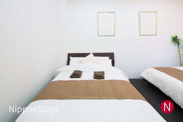 A simple hotel room with two beds made up side by side