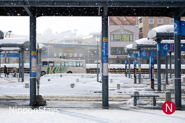 Covered bus bays under snow at a winter bus terminal in northern Japan