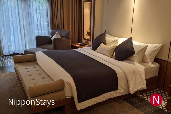 A plain modern hotel room with a bed and desk