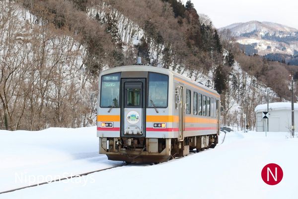 A local train crossing a snow-covered valley in Nagano