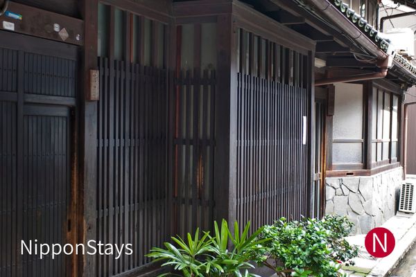 Traditional wooden machiya townhouses on a street in Kyoto