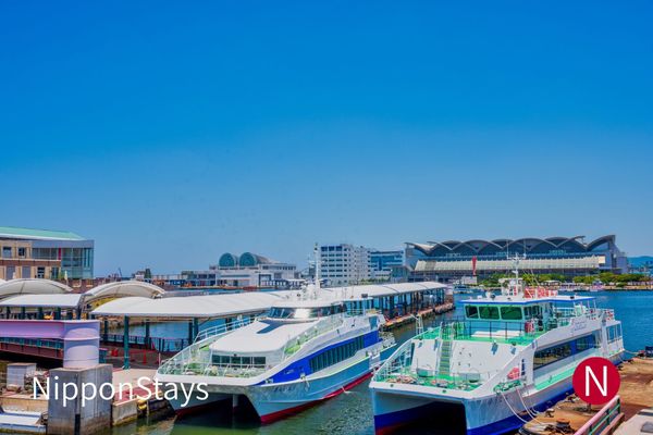 Ferries moored at Hakata's bayside terminal under a summer sky