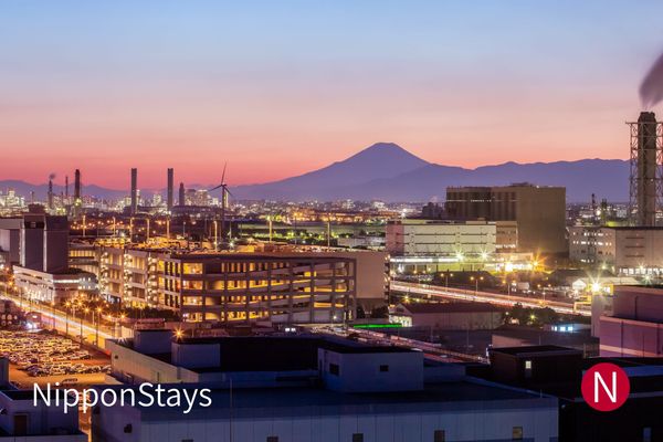 The Kawasaki industrial waterfront at dusk with Mount Fuji behind it