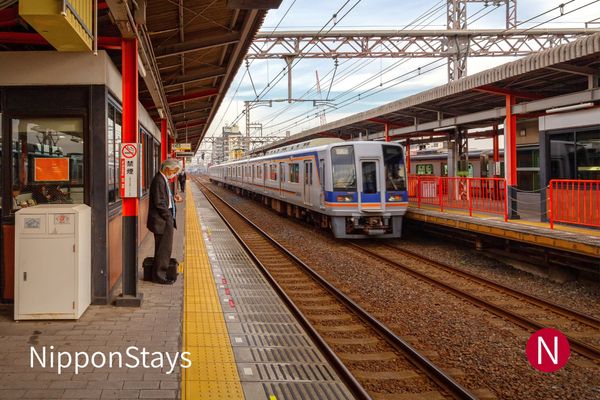 A commuter train arriving at a Japanese station platform