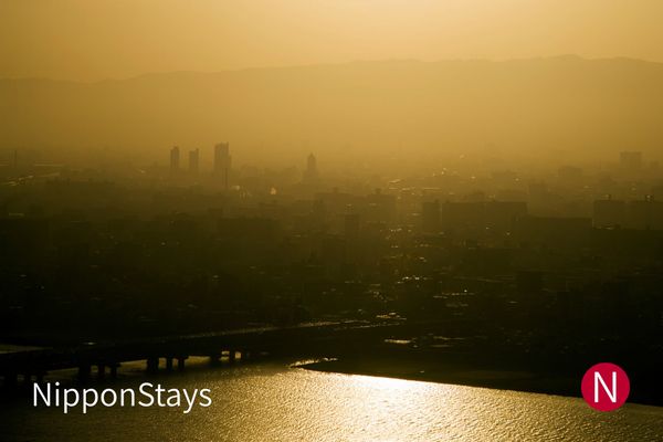 Osaka skyline at dusk across the Yodo River toward Osaka Bay