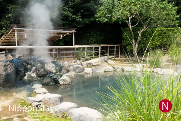 Steam rising from an open-air hot-spring bath in Beppu