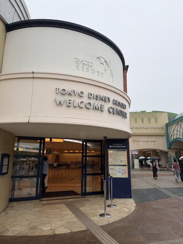 Tokyo Disney Resort Welcome Center entrance beside Resort Gateway Station on an overcast day