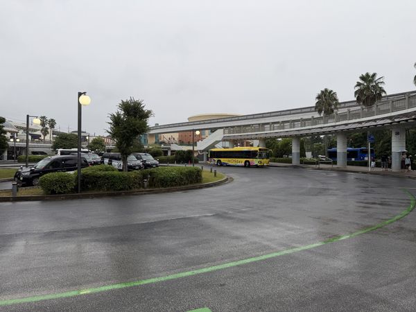 Bus and taxi rotary at the south exit of JR Maihama Station with a hotel shuttle bus and the Disney Resort Line overhead