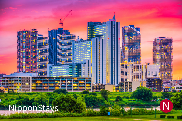 Kawasaki skyline at dusk with modern high-rise buildings and an open sky.