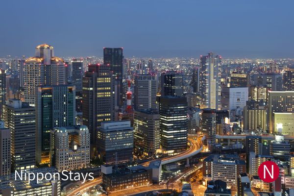 Osaka skyline at dusk with high-rise hotels and an expressway curving between them