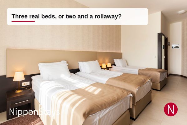 Three beds of the same width lined up side by side in a hotel room