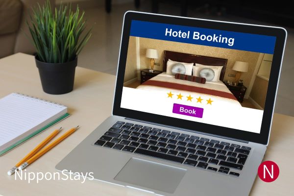 A laptop on a desk showing a hotel booking page