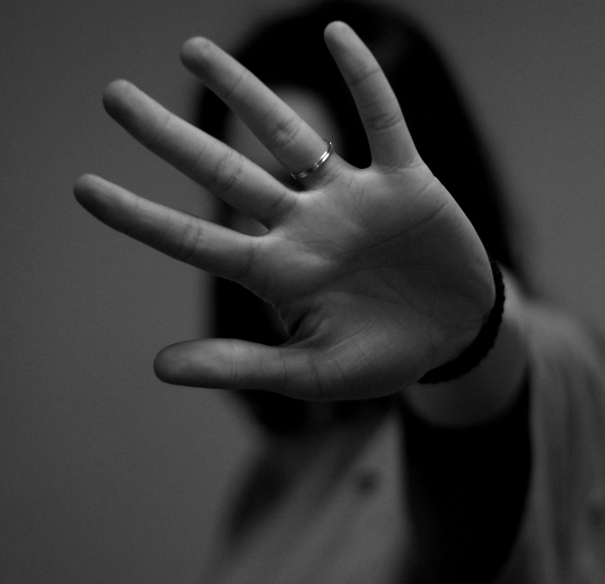 woman showing left hand with wedding band