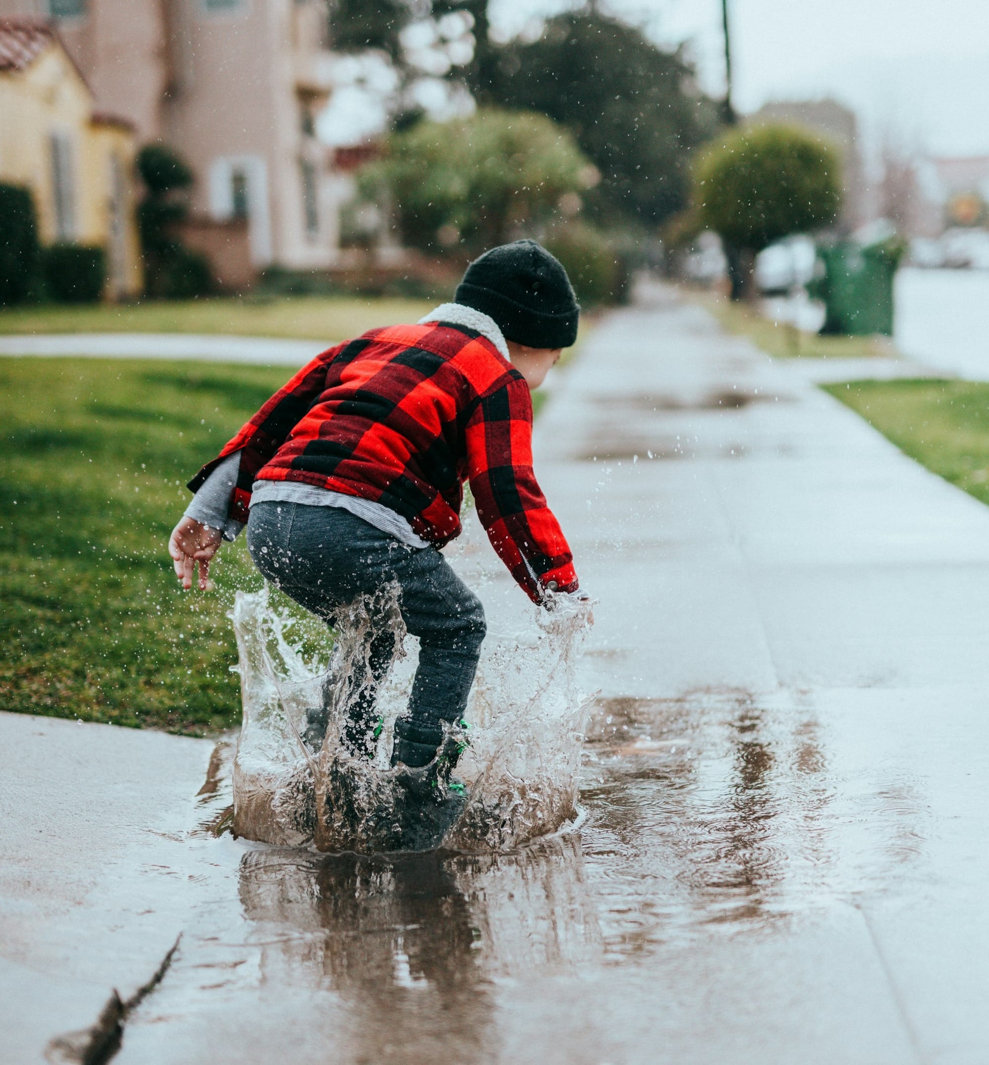boy in red and blue striped sweater and blue denim jeans running on road during daytime