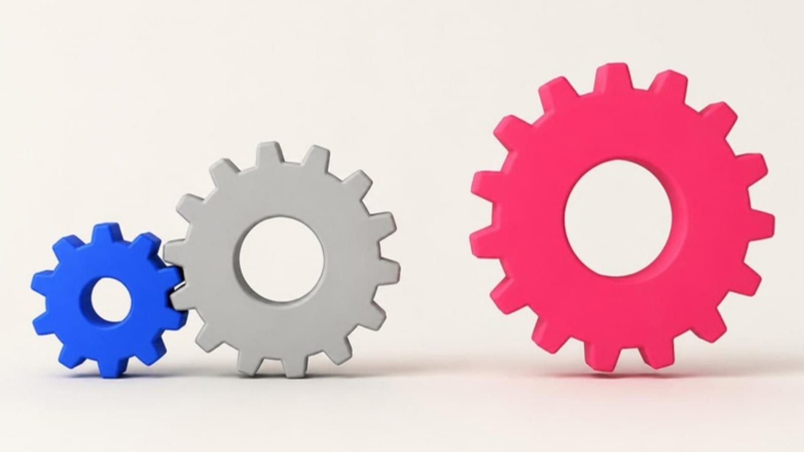 A small blue gear and a grey gear mesh together, while a large pink gear stands apart and does not turn.