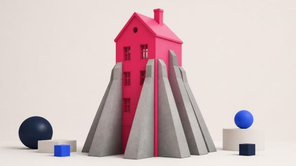 A pink house held up by grey stone buttresses on every side.
