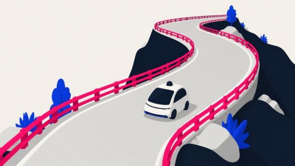 A driverless car travels a winding mountain road lined with pink guardrails.
