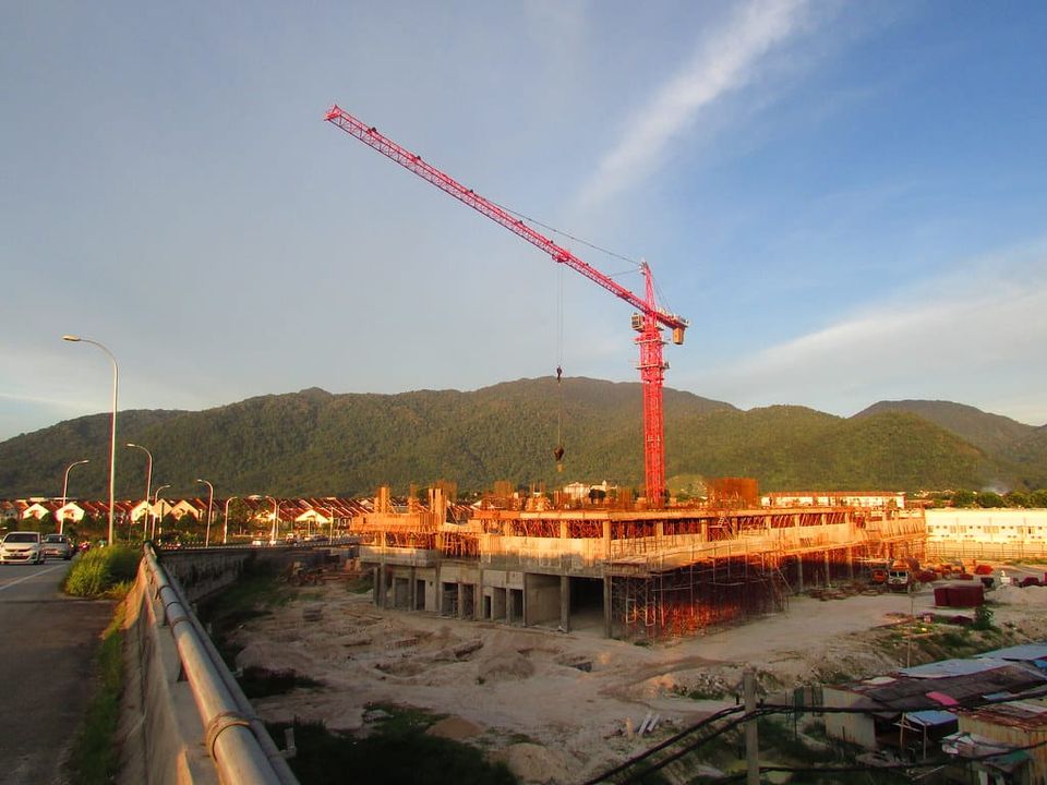 Baustelle mit Baukran bei einem Wohnbauprojekt im Abendlicht
