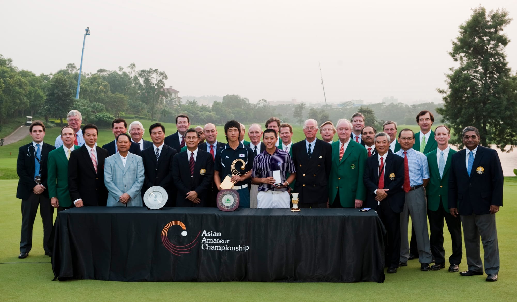 Han Chang-won and Eric Chun pose with officials from the APGC, The R&A, Masters Tournament and Mission Hills.