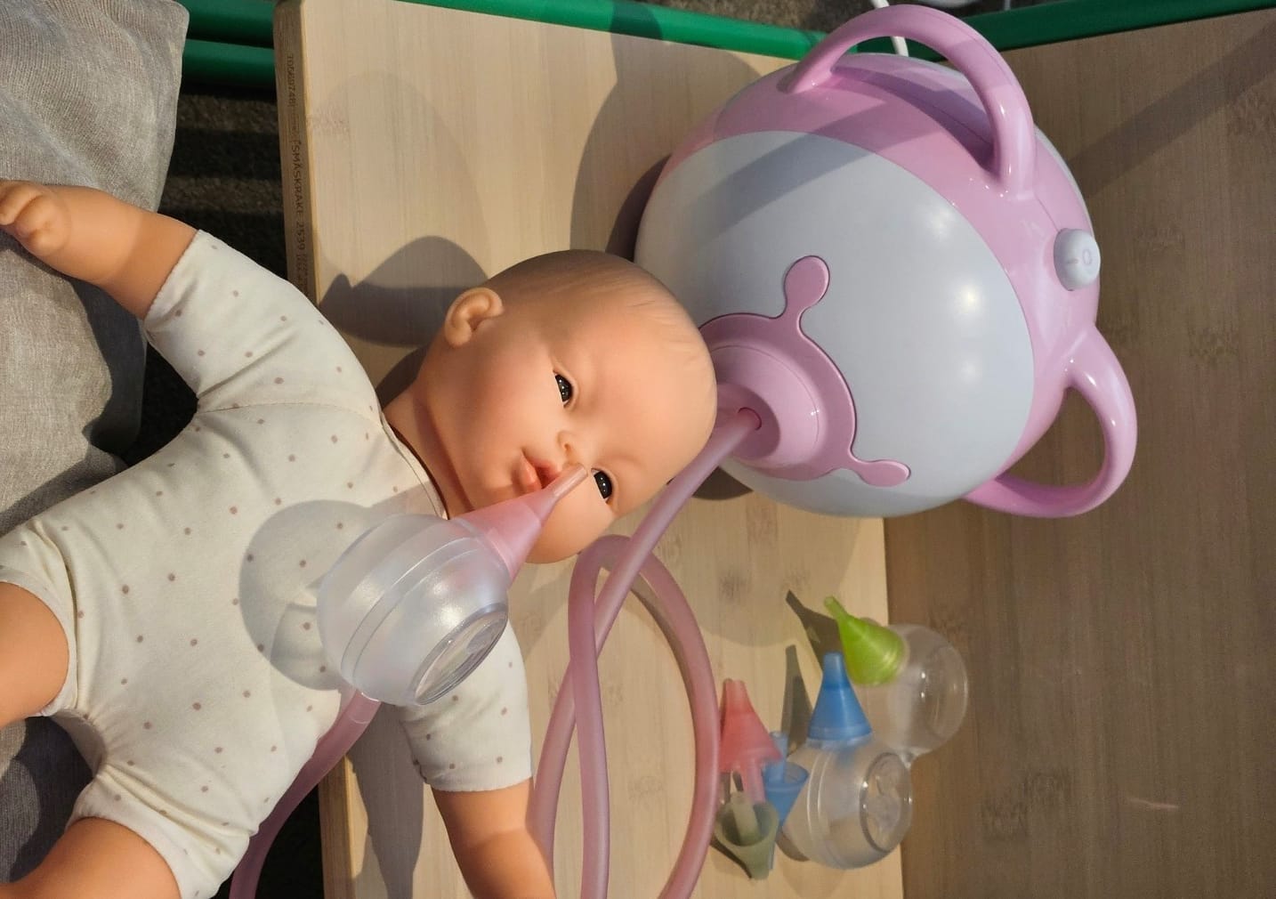 Nosiboo electric nasal aspirator on an infant doll