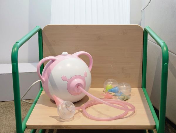 Nosiboo Pro electric nasal aspirator on a wooden nursery shelf — best baby nasal aspirator for newborns and toddlers