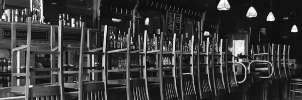 Sedie capovolte sul bancone di un locale chiuso. Ferie e permessi ristorazione HoReCa