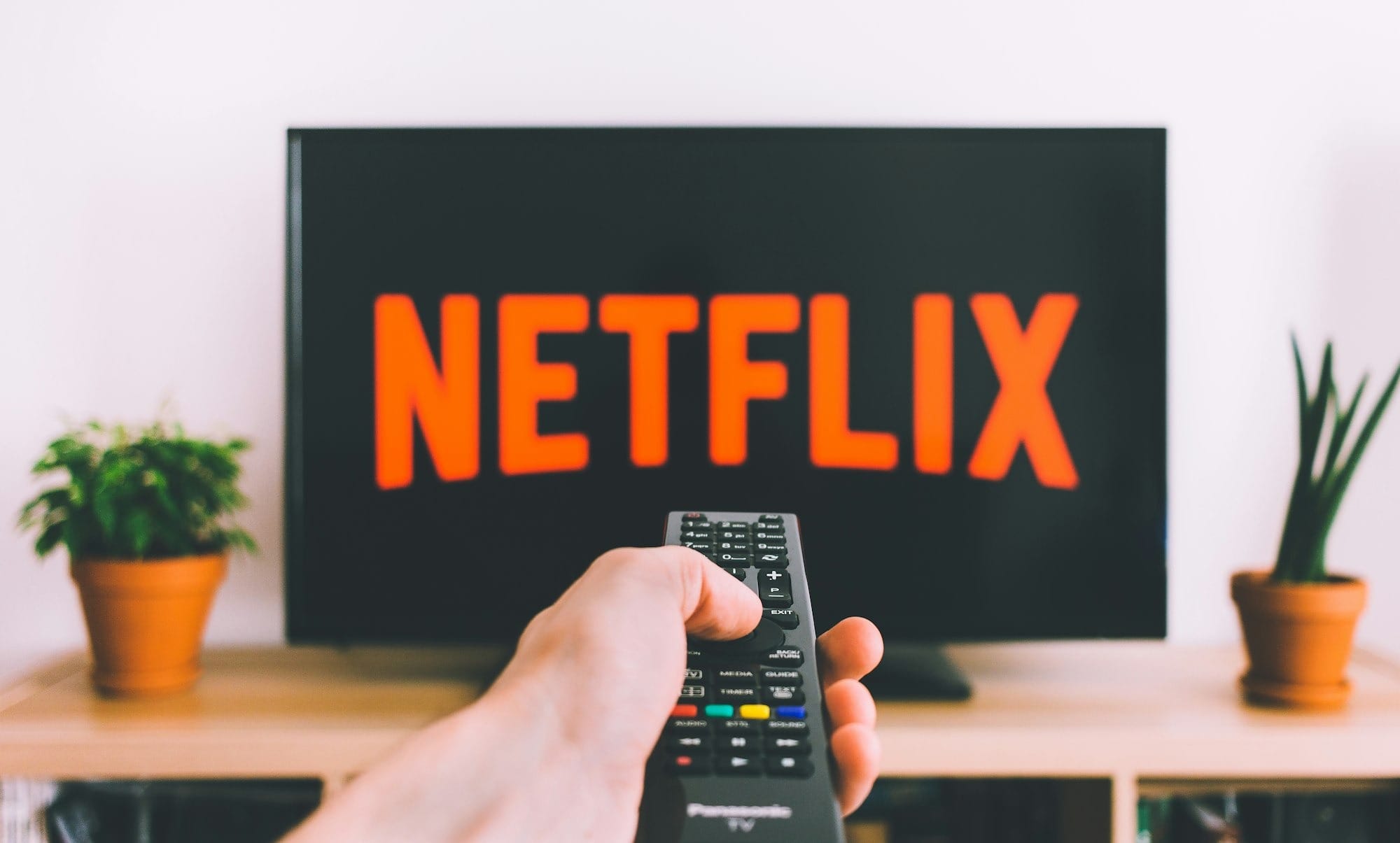 person holding remote pointing at TV