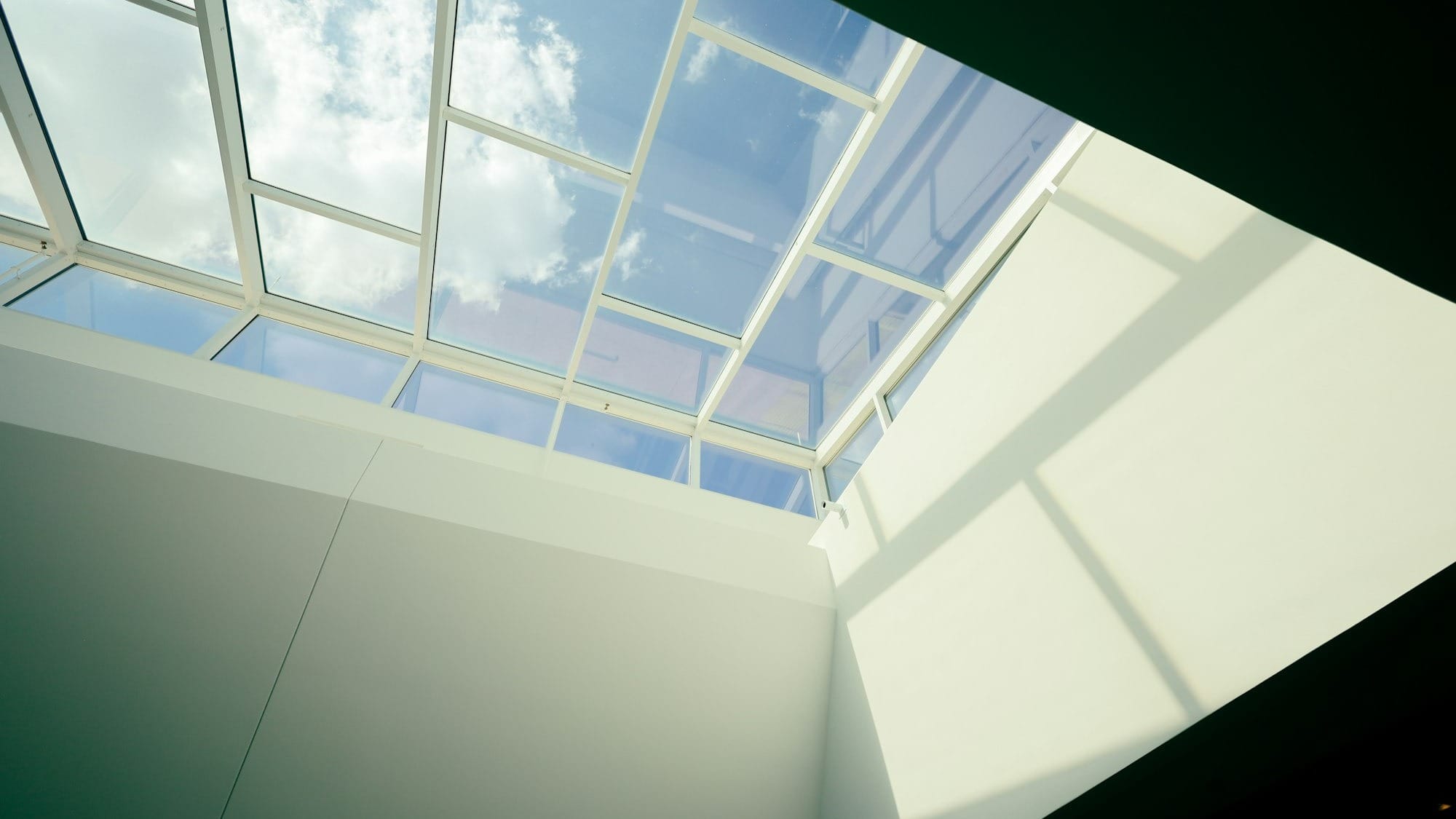 a room with a skylight and a white wall