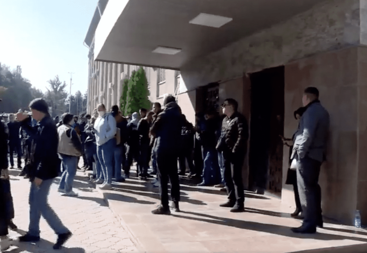 В здании правительства проходит встреча лидеров партий. У входа собирается митинг