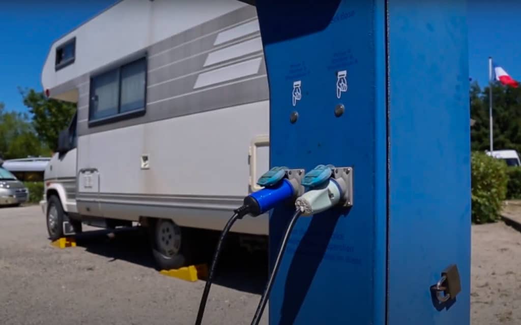 Motorhome plugged into the electricity supply at a French service point