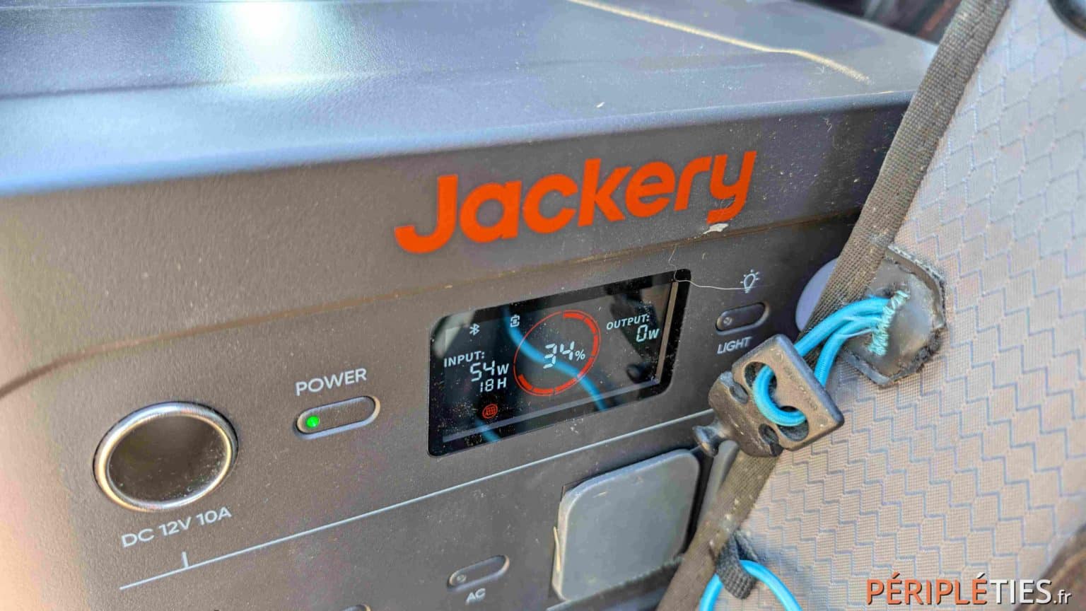 The home charging cable plugged into the Jackery's AC outlet