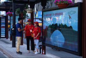 Deux bénévoles renseignent un passager dans une station de bus à quelques jours du 11e Sommet du G20 à Hangzhou, capitale de 