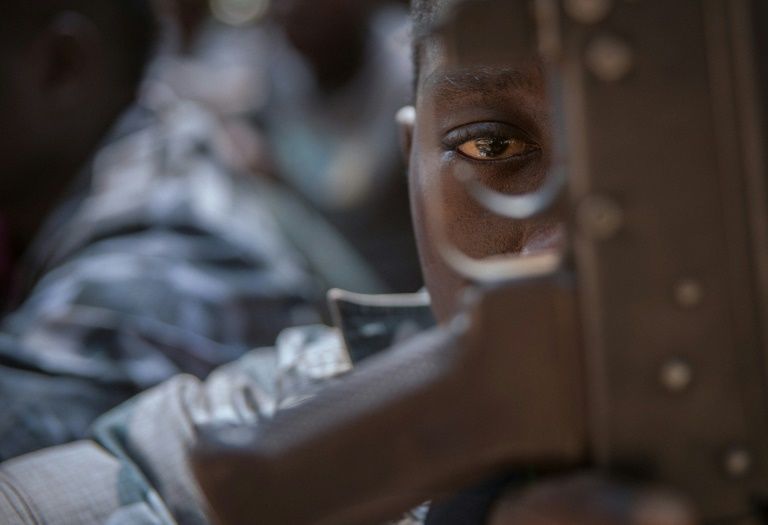 Un enfant-soldat regarde à travers la crosse d'un fusil au cours d'une cérémonie de libération à Yambio, au Soudan du Sud, le