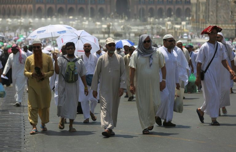 Des pèlerins musulmans marchent dans une rue de la ville sainte de la Mecque en Arabie saoudite avant le début du hajj annuel