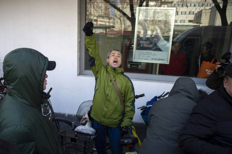Le militant Yang Chunlin (c) crie son soutien à Me Wang Quanzhang devant le tribunal de Tianjin où se déroule le procès de l'