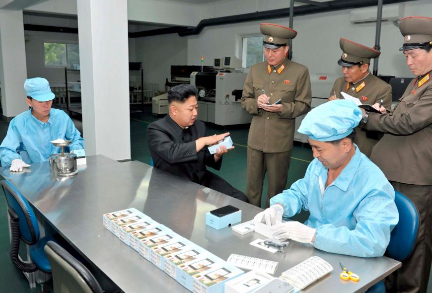 Kim Jong-Un observe le nouveau smartphone « made in Coree du Nord » dans l'usine de Pyongyang