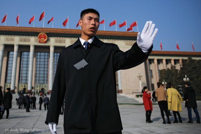 Un soldat en tenue de ville empêche des journalistes de s’approcher trop près du Grand Hall du peuple à Beijing, en mars. (© 