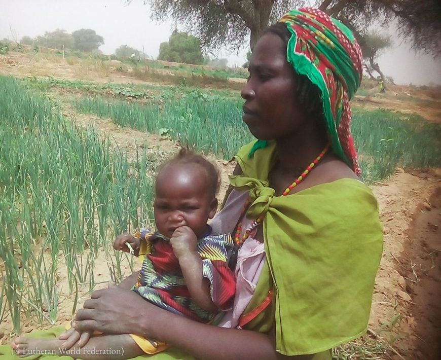 Fatima (un nom d’emprunt) tient sa fillette contre elle près du camp de réfugiés de Tolgo, au Tchad, en 2019. (© Lutheran Wor