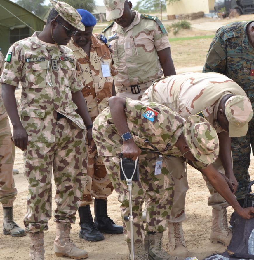 Des officiers de la Force mixte multinationale inspectent du matériel saisi sur des terroristes au Lac Tchad. Image d'illustr