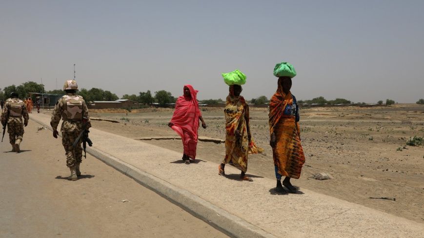 Des femmes passent devant des soldats sur un pont séparant le Cameroun et le Nigéria, à Gamboru Ngala, Borno, Nigéria, le 27 